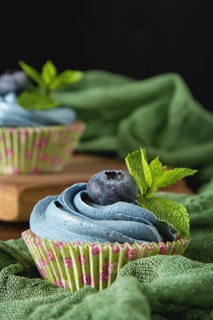 Capecake, Muffin with blue cream. Birthday and wedding. A delicious holiday. Dark backgroundの写真素材