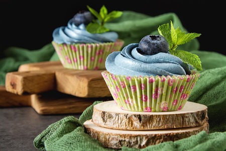 Capecake, Muffin with blue cream. Birthday and wedding. A delicious holiday. Dark backgroundの写真素材