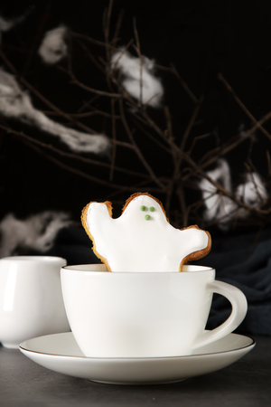 Sweet Halloween. Hot cocoa with cookies in the form of ghosts, leaves and pumpkins. Dark background. Space for textの写真素材