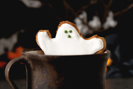 Sweet Halloween. Hot cocoa with cookies in the form of ghosts, leaves and pumpkins. Dark background. Space for textの写真素材