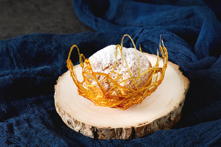 Italian dessert is profiterole with cream and caramel decoration. Dark backgroundの写真素材
