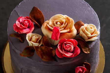 Chocolate cake with flowers for birthday. Dark background
