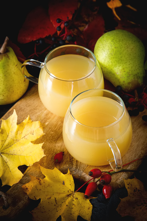 Pear grog or cider in autumn leaves with cinnamon. Dark backgroundの写真素材