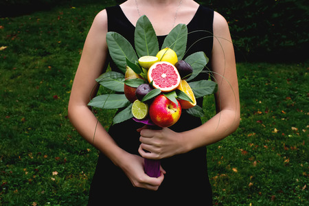 The original unusual edible bouquet of vegetables and fruits in a handsの写真素材