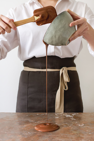 The girl is preparing hot milk chocolate. White backgroundの写真素材