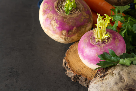 Ripe turnips, beets, carrots, pumpkin and parsley. Dark background. Vegetarian foodの写真素材