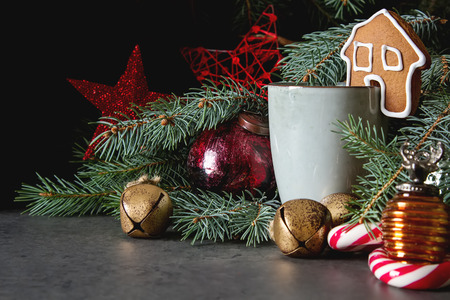 New Year gingerbreads with a cup of hot chocolate. Christmas tree and toys. Dark backgroundの写真素材
