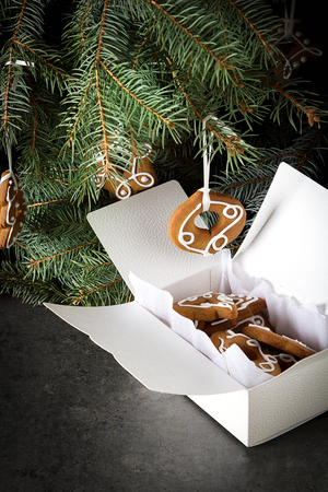 Gingerbread cakes with branches of a Christmas tree. decoration. Dark backgroundの写真素材