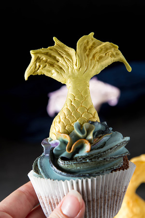 cupcakes berry with tail of a mermaid of mastics. Sweet dessert for a birthday. Dark backgroundの写真素材