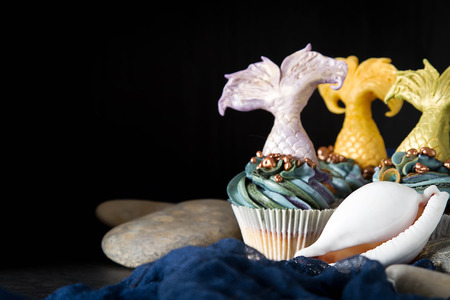 cupcakes berry with tail of a mermaid of mastics. Sweet dessert for a birthday. Dark backgroundの写真素材