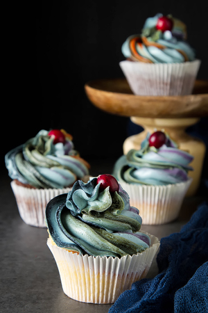 cupcakes on a wooden board. Sweet dessert for a birthday. Dark backgroundの写真素材