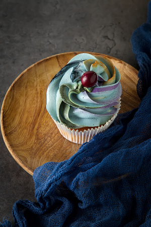 cupcakes on a wooden board. Sweet dessert for a birthday. Dark backgroundの写真素材