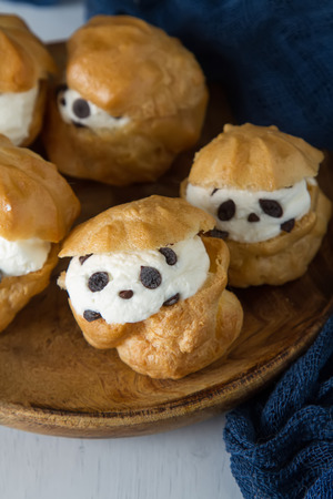 Profiteroles with cream and chocolate. Dark backgroundの写真素材