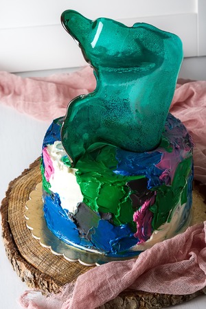 Birthday cake with green caramel. White background