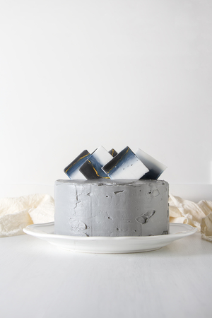Birthday cake with a gray cream. White backgroundの写真素材