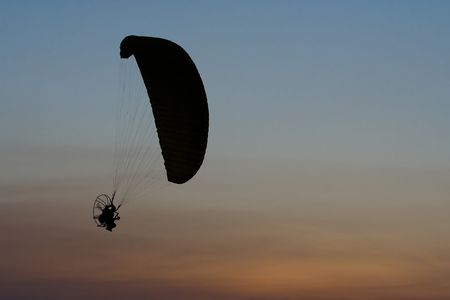 Image of paramotor flying on sunset background.の写真素材