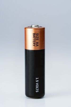 Closeup photo on small battery with positive and negative signs.
