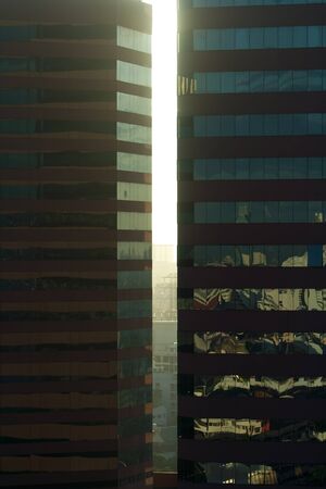 Angled shot of an office building with shiny blue glass facade on a sunny day.の写真素材
