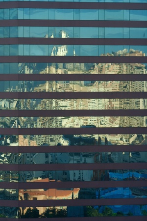 Angled shot of an office building with shiny blue glass facade on a sunny day.の写真素材