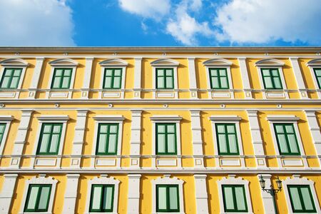 Building office is painted with green windows and yellow wall with design.の写真素材