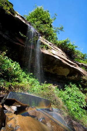 Waterfall in tropical rainforest with rainbow.の写真素材
