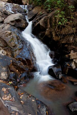 Waterfall in tropical rainforest with rainbow.の写真素材