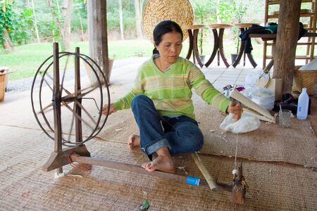 Traditional old style for pulling out silk thread from the cocoon and spining them to keep on spool. Image is taken on 2008-12-25 in Thailand.のeditorial素材