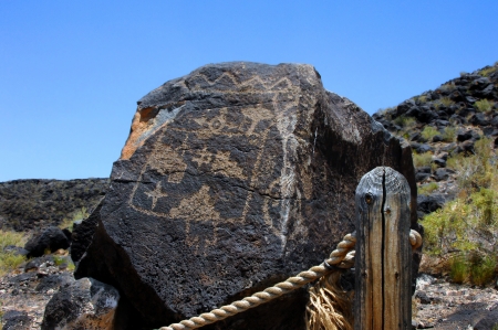 Large basalt rock has Pueblo Indian petroglyph   Roped trail leads through one of the trail options in the Petroglyph National Monument in Albuquerque, New Mexico のeditorial素材