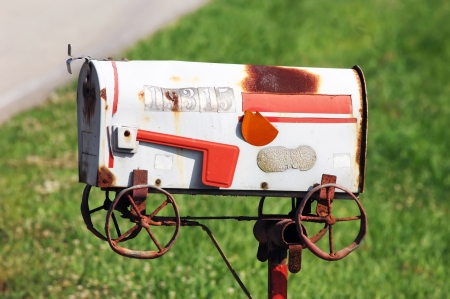 Metaphoric mailbox shows this family has moved.  Handmade mailbox design depicts a "moving" wagon.  Abandoned by family, mailbox sits rusting and derelict on iron post.の写真素材