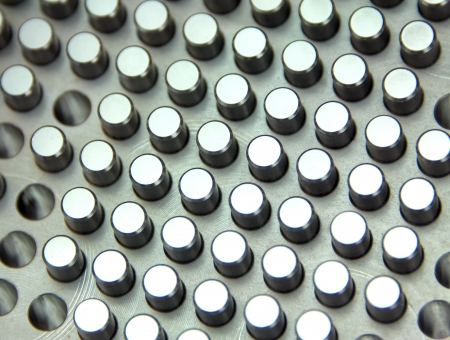 Perfectly shaped metal pegs fit in perfectly shaped metal holes in this closeup detail of an industrial control board.の写真素材