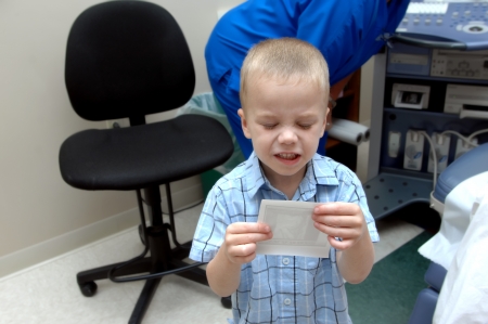 Little boy sees the ultra sound image of his soon to be "little brother" and he is not impressed.  He is totally grossed out.の写真素材