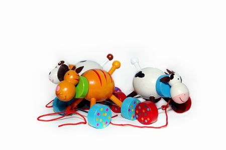 Three old fashioned wooden toys are surrounded by white   Each is painted in bright colors and roll on wheels   Red pull strings and fun dots complete the design の写真素材