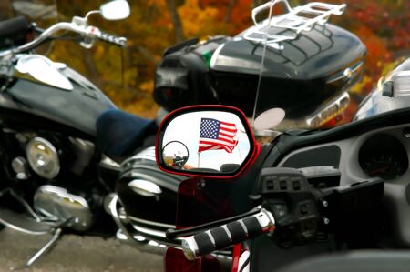 Photographer is captured in a doubled mirror image of American flag in the rear view mirror of motorcycle flying the American flag. の写真素材