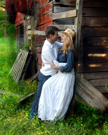 Rustic, weathered barn serves as backdrop for romantic coupleの写真素材
