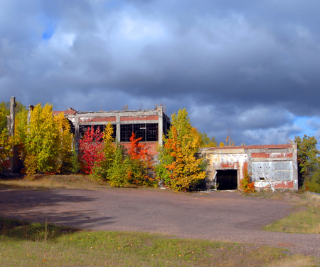 Fall trees and threatening sky frame abandoned Quincy Mining Company Stamp Mill.  A relic from the copper mining industry in the Keweenaw Peninsula of Michigan.の写真素材