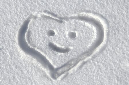 Drawing of a smiling heart lays on a fresh layer of snow in Colorado.の写真素材