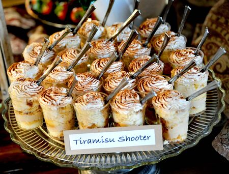 Wedding reception offers guests a Tiramisu Shooter.  Plate holds group of desert glasses with...