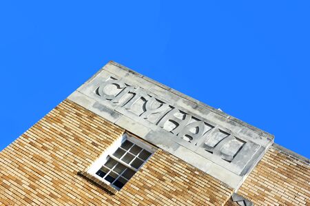 City Hall in Eudora, Arkansas is framed by blue sky.  Tilted angle image shows the words City Hall...