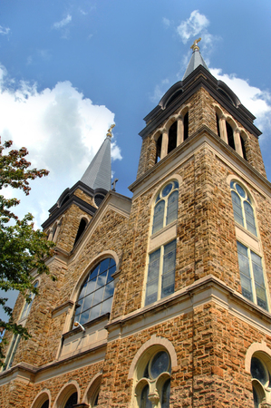 Corner angle shows both bowers and reflection in window of the Sacred Heart of Jesus Catholic Church in Cullman, Alabama.の写真素材
