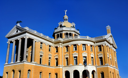Harrison County Courthouse in Marshall, Texas receives a facelift.  Worker standing on a tall ladder repaints the trim on upper story windows.の写真素材