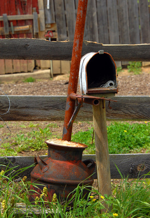 Abandoned mial box has no door, holds a spool of string and serves as a prop for a milk can and pole.  Farm stands abandoned in Tennessee
の写真素材