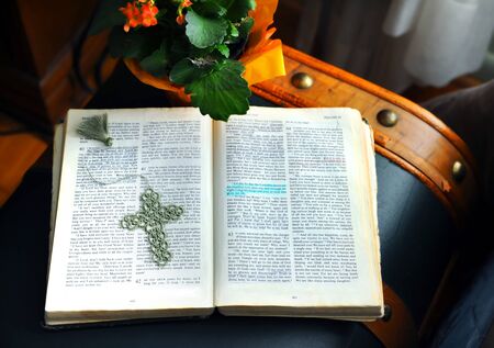 Bible lays across an old trunk.  Hand crocheted cross book mark lays on open page.  Highlight shows words of encouragement and hope.の写真素材