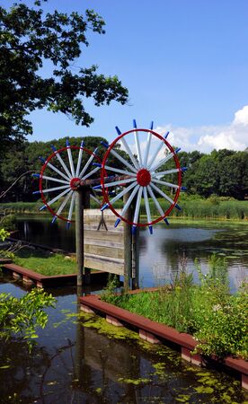 Sluice gate, on the Macatawa River, stands open at Windmill Island Gardens in Holland Michigan.  Gate is Dutch style and painted red, white and blue.の写真素材