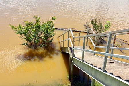 Water has risen over the metal viewing area and walkway to boat ramp at the Camden River Front Access on the Ouachita River in Camden, Arkansas.の写真素材