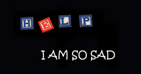 Wooden block letters spell the word help with a message that says I am so sad on a magnetic board. ...
