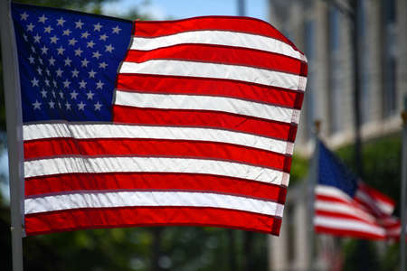 Sunlight causes American flag to glow as it flutters in front of a church in El Dorado, Arkansas.