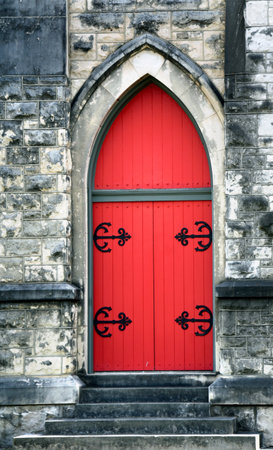 Red door with black decorative hinges is side entrance to the St. Mary Episcopal Cathedral in Memphis, Tennessee.の写真素材