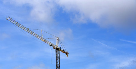 Tall crane and extension stands over the blue skies of Memphis, Tennessee.  Building and expansion shows progress in action.の写真素材