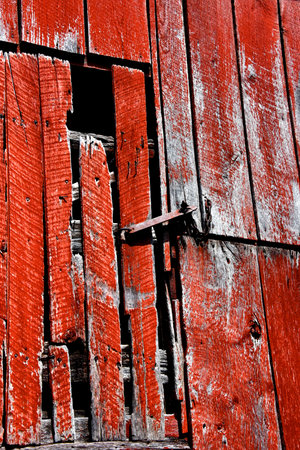 Rusty and old, metal hardware holds loft door closed.  Barn is red, wooden and weathered with age.の写真素材