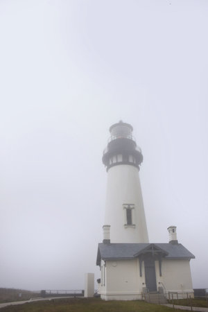 The Yaquina Head Lighthouse, near Newport, Oregon, is shrouded in fog.  It sits on Yaquina Head.の写真素材